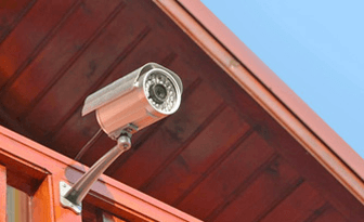 Уличная видеокамера, установленная на стене частного дома