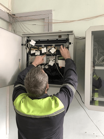 Инженер проводит диагностику оборудования видеонаблюдения в слаботочном щитке