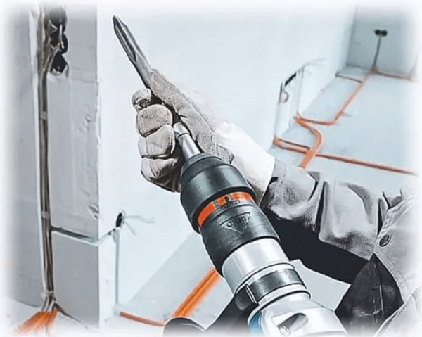 Электромонтажник с перфоратором в квартире
