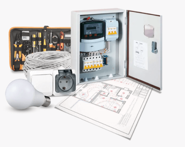 На фоне проекта электрощит в сборе, бухта электропровода,розетка, выключатель, лампочка, набор инструментов.