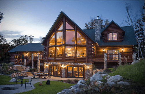 Дом из дерева с включенным освещением на фоне улицы.